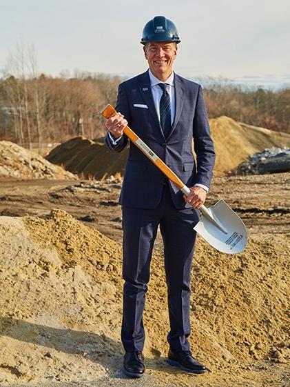UNE President James 赫伯特 poses with a shovel at the groundbreaking 